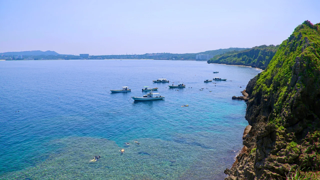 Japonya Okinawa’da Maeda Burnu kıyısı, berrak deniz ve dalış tekneleri